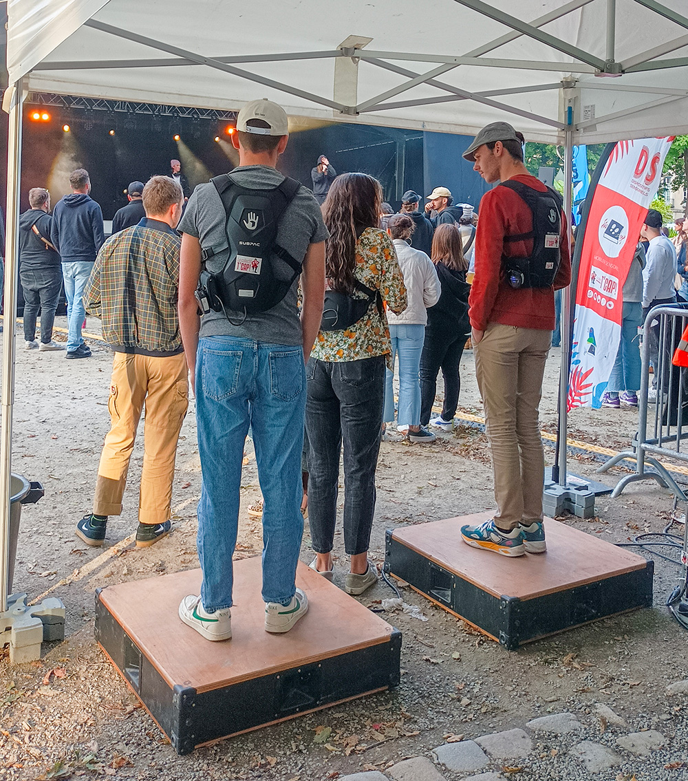 photo des 2 hommes portants des gilets vibrants, debout sur des caissons vibrants