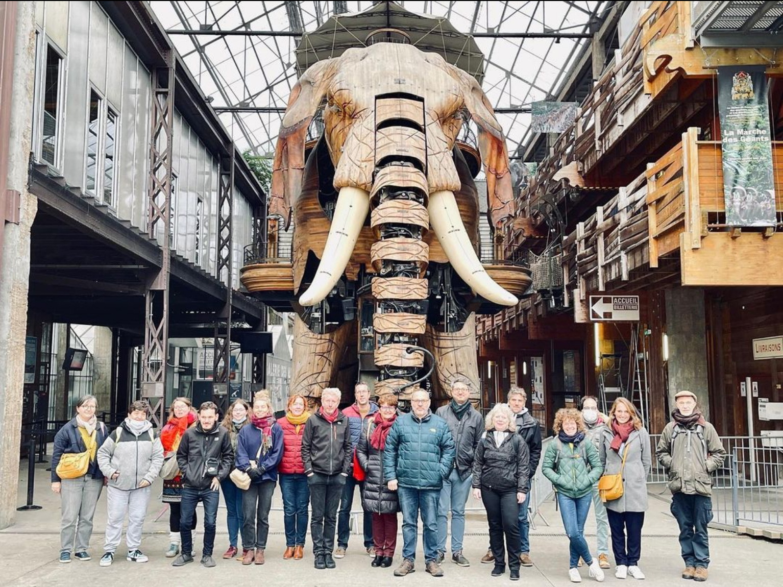 un groupe de personnes, du collectif t'cap, sont en ligne devant l'éléphant mécanique de Nantes
