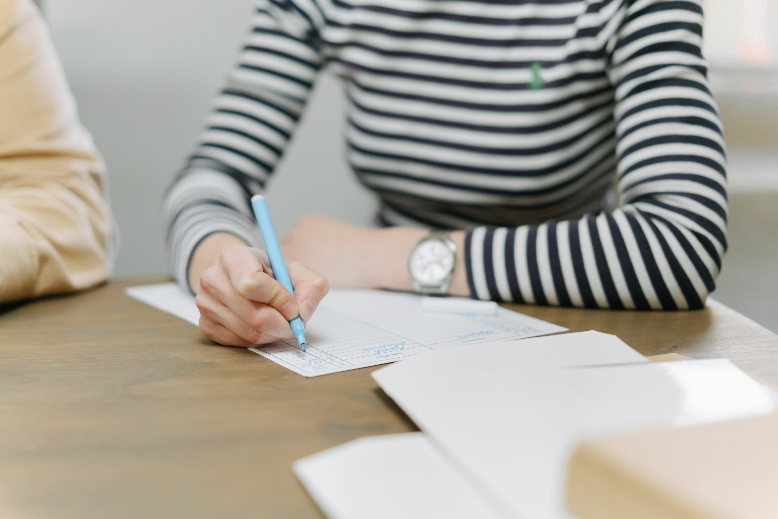 femme remplissant un document papier avec un feutre